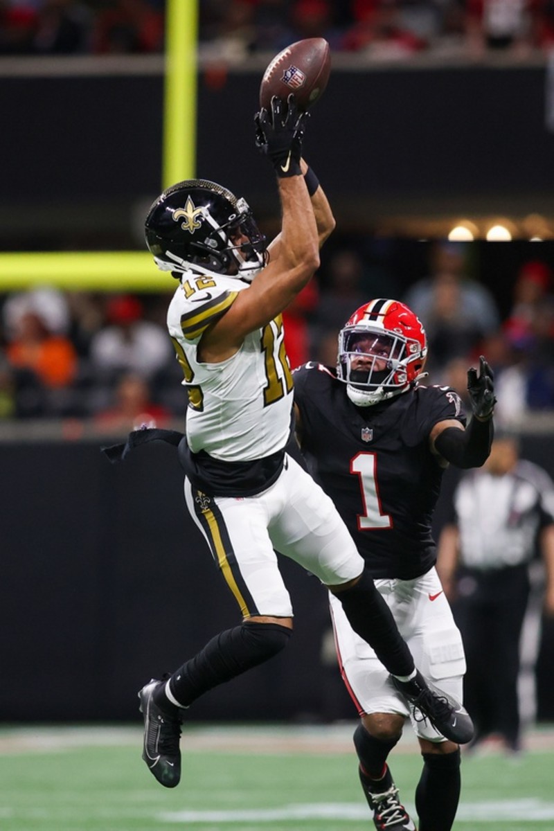 New Orleans Saints receiver Chris Olave (12) catches a pass over Atlanta Falcons cornerback Jeff Okudah (1). Mandatory Credit: Brett Davis-USA TODAY Sports
